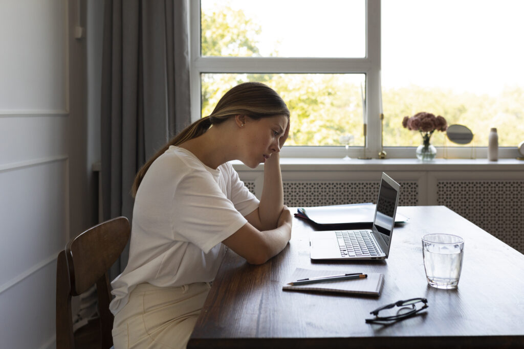 femme seule, pensive au bureau sentiment d'illégitimité syndrome de l'imposteur