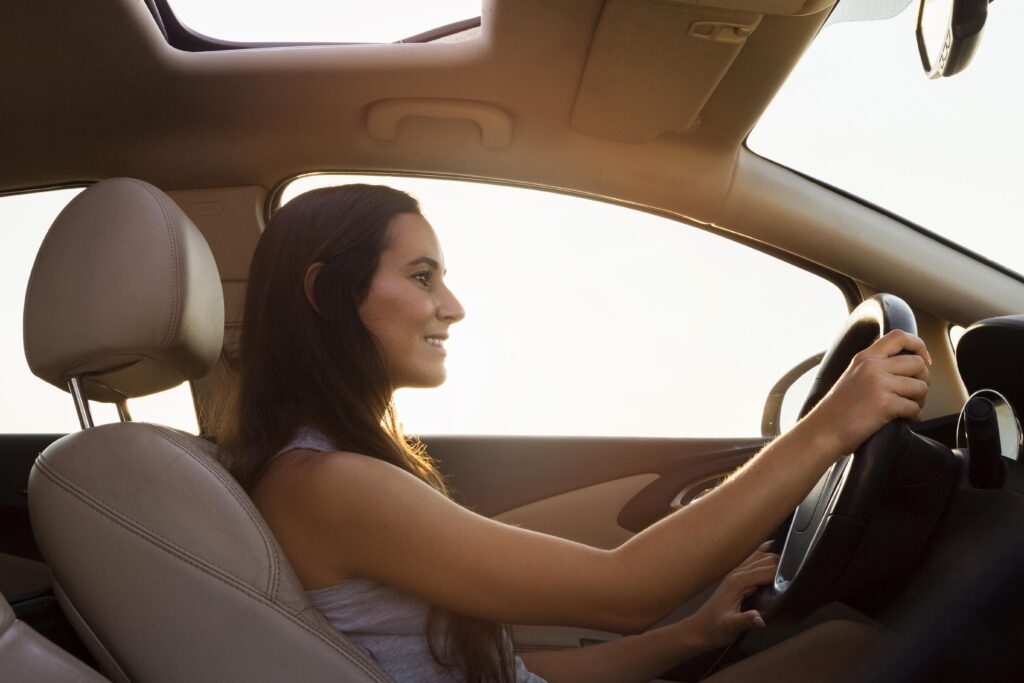 Femme assise au volant après une crise de panique en voiture, retrouvant progressivement son calme.